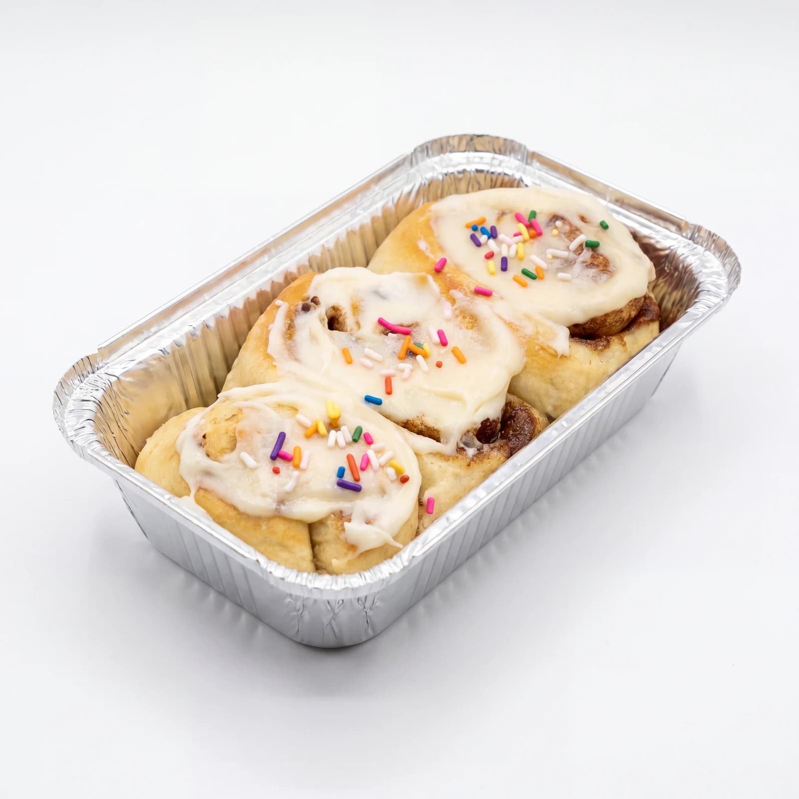 A foil tin of cinnamon sprinkle rolls with cream-cheese glaze.